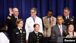 សមាជិក​ម្នាក់​នៃ​ក្រុម​យោធា​អាមេរិក​ប្រយុទ្ធ​នឹង​ជំងឺ​អ៊ីបូឡា​លើក​ដៃ​របស់​គាត់​នៅ​ពេល​លោក​ប្រធានាធិបតី​អាមេរិក បារ៉ាក់ អូបាម៉ា (រូប​ស្តាំ​ទី​២) និយាយ​ពី​ឈ្មោះ​របស់​គាត់​នៅ​ក្នុង​សុន្ទរកថា​របស់​លោក​ប្រធានាធិបតី​នៅ​សេតវិមាន​ រដ្ឋធានី​វ៉ាស៊ីនតោន។