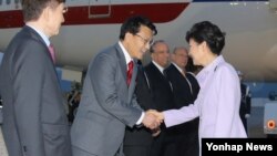 지난달 27일 중남미 4개국 순방을 마치고 귀국한 박근혜 한국 대통령이 성남 서울공항에서 전용기에서 내린 뒤 정무특보인 새누리당 윤상현 의원과 악수를 하고 있다. (자료사진)