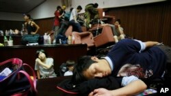 Seorang mahasiswa demonstran tidur di lantai parlemen setelah bentrok dengan polisi di Taipei, Taiwan, Rabu (19/3).