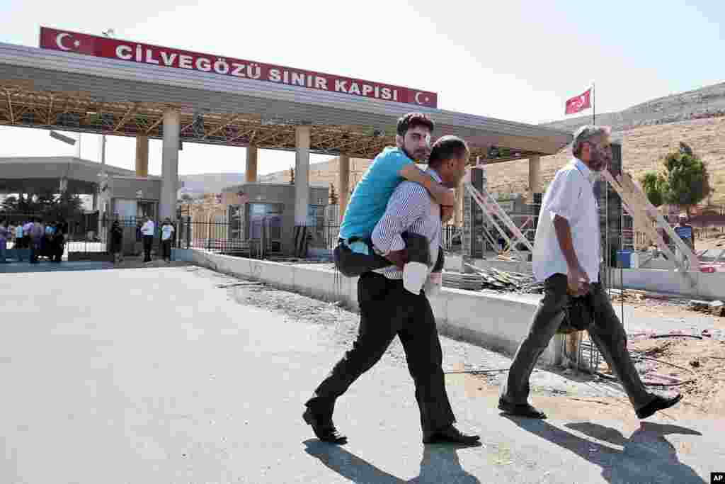 Mustafa Abu Bekir is carried on the shoulder of a relative as he arrives at the Turkish Cilvegozu gate border, Sept. 9, 2013.