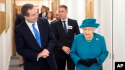 Britain's Queen Elizabeth II, right, walks with Director of GCHQ (Government Communications Headquarters) Robert Hannigan, during a visit to officially open the National Cyber Security Center (NCSC) in London, Feb. 14, 2017.