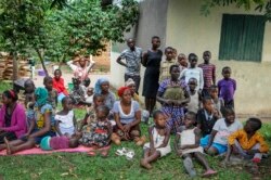 Relatives of the 5-year-old boy who became Ebola's first cross-border victim, and others, listen as village leaders and health workers educate them about Ebola, in Kirembo, Uganda, June 15, 2019.