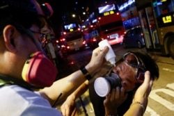 A medic treats an anti-extradition bill protester after tear gas was fired during clashes in Sham Shui Po in Hong Kong, Aug. 14, 2019.