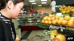 Seorang warga China hendak berbelanja buah-buahan yang diimpor dari Florida, AS di sebuah supermarket di Beijing (foto: ilustrasi). 