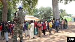 Un soldat monte la garde près d'anciens enfants soldats anti-Balaka attendant d'être libérés d'un camp à Batangafo, en République centrafricaine, 28 août 2015. 