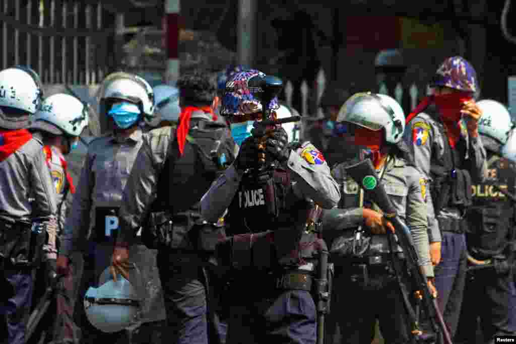 A riot police officer opens fire on protesters during a protest against the military coup in Yangon, Myanmar, Feb. 28, 2021.
