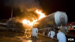 Tim pemadam kebakaran Pakistan mencoba memadamkan kebakaran sebuah truk tangki minyak setelah serangan oleh Taliban.