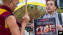 Member of the Tibetan Parliament in exile Thubten Wangchen, left, together with another protestor hold the Tibetan flag during the 'Flame of Truth' rally, near the European Commission headquarters in Brussels, September 20, 2012. 