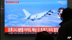 People watch a TV screen showing file footage of a Japanese patrol plane during a news program at the Seoul Railway Station in Seoul, South Korea, Jan. 23, 2019. 