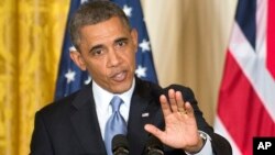 President Barack Obama gestures during a joint news conference with British Prime Minister David Cameron, in the East Room of the White House in Washington, May 13, 2013.