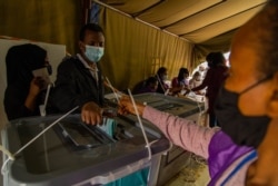 An Ethiopian voter cast his vote in Addis Ababa, Ethiopia, June 21, 2021. (VOA/Yan Boechat)