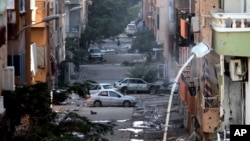 FILE - Damages are seen due to clashes between the Libyan military and Islamic militias in Benghazi, Libya. Representatives of Libya's rival factions who are sitting in Tunis and negotiating through a U.N.-brokered process announced on Tuesday that they have formed a unity government aimed at stemming the chaos that has engulfed the country for the past years.