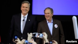 Kandidat Capres partai Republik, Jeb Bush (kiri) tampil dalam kampanye bersama kakaknya, mantan Presiden George W. Bush, di Charleston, South Carolina, Senin malam (15/2).