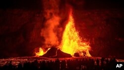 Туристы наблюдают, как вулкан Килауэа выбрасывает фонтан лавы во время извержения, 3 февраля 2025 года (Janice Wei/NPS via AP)