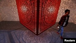 Seorang pengunjung berjalan di sebelah sebuah pameran berjudul "All The Flowers Are For Me" oleh seniman Pakistan-Amerika Anila Quayyum Agha di Pameran Seni India di New Delhi, India, 3 Februari 2017. (Foto: Reuters)