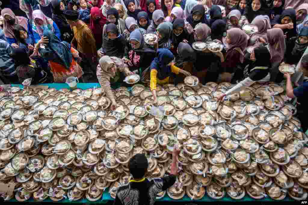 Umat Muslim menerima makanan berbuka puasa yang disediakan gratis selama bulan suci Ramadan di Masjid Jogokariyan di Yogyakarta. (Devi Rahman/ AFP)