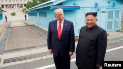 រូបឯកសារ៖ ប្រធានាធិបតី​សហរដ្ឋ​អាមេរិក លោក ដូណាល់ ត្រាំ និង​មេដឹកនាំ​កូរ៉េ​ខាង​ជើង គីម ជុងអ៊ុន ស្ថិត​នៅ​តំបន់​គ្មាន​កង​ទ័ព នៅ ព្រំដែន​កូរ៉េ​ខាង​ជើង​និង​ខាង​ត្បូង កាល​ពី​ខែ​មិថុនា ២០១៩។