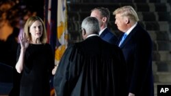 ប្រធានាធិបតី​សហរដ្ឋអាមេរិក​លោក Donald Trump ឈរ​មើល​អ្នកស្រី Amy Coney Barrett ស្បថ​ចូល​កាន់​តំណែង​ជា​ចៅក្រម​តុលាការ​កំពូល​នៅ​សេតវិមាន ថ្ងៃទី២៦ ខែតុលា ឆ្នាំ២០២០។ 