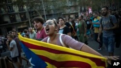 ស្ត្រី​ម្នាក់​កាន់​ទង់ជាតិ​ Catalan ​ខណ​ដែល​បាតុករ​ហែ​រក្បួន​នៅ​ក្នុង​ទីក្រុង​ Barcelona ប្រទេស​អេស្ប៉ាញ​កាលពី​ថ្ងៃពុធ​ទី​០៣ តុលា ២០១៧។