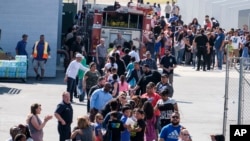 Staf sekolah menyambut murid North Park Elementary School, dengan perasaan lega di Cajon High School, hari Senin 10 April 2017 di San Bernardino, California, setelah penembakan maut yang terjadi di sekolah dasar itu (foto: AP Photo/Ringo H.W. Chiu)