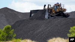 Heavy machinery moves coal at a mine near Muswellbrook in the Hunter Valley, Australia, Tuesday, Nov. 2, 2021.