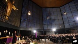 FILE - The Archbishop of Berlin, Heiner Koch, left, speaks during a memorial service in the Kaiser-Wilhelm Memorial Church in Berlin, Dec, 20, 2016, for the victims of an attack with a truck at a Berlin Christmas market.
