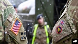 资料照片：在德国布吕克举行的有关“捍卫者-2020“演习的一次记者会后，美英军人并肩站立。(2020年2月26日)