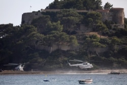 Russian President Vladimir Putin's helicopter, right, lands at the Fort de Bregancon before his meeting with French President Emmanuel Macron, Aug.19, 2019 in Bormes-les-Mimosas, southern France.