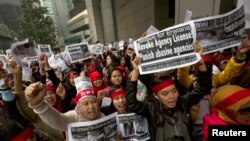 Pembantu Rumah Tangga dan pendukungnya dengan foto Erwiana Sulistyaningsih, seorang pembantu asal Indonesia yang diduga disiksa oleh majikannya di Hong Kong 19 Januari 2014.
