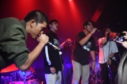 FILE - An audience member, second from right, raps with members of Rap Against Dictatorship on stage in Bangkok, Oct. 27, 2018. The group has touched a nerve with an impassioned and now-viral music video lobbing fiery rhymes at the ruling junta.
