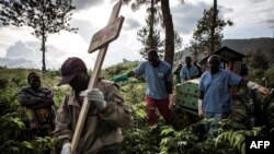 Health workers carry a coffin containing a victim of Ebola virus on May 16, 2019 in Butembo.