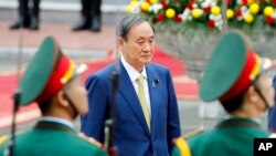日本首相菅义伟在越南河内总统府检阅仪仗队。（2020年10月19日）