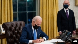 FILE - Secretary of Homeland Security Alejandro Mayorkas looks on as President Joe Biden signs an executive order on immigration, in the Oval Office of the White House, Feb. 2, 2021, in Washington.
