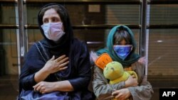 Iranians wearing face masks to protect against the coronavirus gather outside their buildings after an earthquake was felt in the capital Tehran, May 7, 2020. 