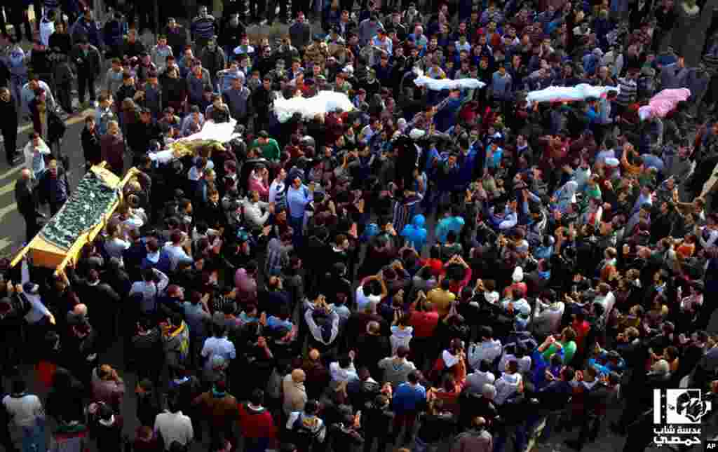 This citizen journalism image provided by Lens Young Homsi, which has been authenticated based on its contents and other AP reporting, shows anti-Syrian regime mourners carrying victims of shelling in Homs, Syria, December 3, 2012.