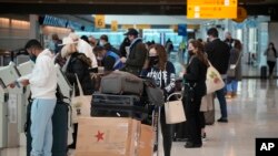 Para calon penumpang antre untuk check in penerbangan United American Airlines di Bandara Internasional Denver, Denver, 26 Desember 2021.