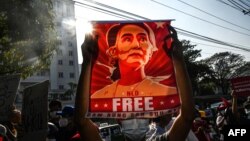 រូប​ឯកសារ៖ បាតុករ​កាន់​រូប​តំណាង​អ្នកស្រី Aung San Suu Kyi កាល​ពី​ថ្ងៃ​ទី​១៥ ខែ​កុម្ភៈ ឆ្នាំ​២០២១ ក្នុង​ទី​ក្រុង​រង់ហ្គូន ក្នុង​អំឡុង​បាតុកម្ម​មួយ​ប្រឆាំង​នឹង​រដ្ឋប្រហារ​យោធា។