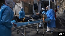 중국 후베이성 우한에서 의료 관계자들이 신종 코로나바이러스 증세를 보이는 환자를 옮기고 있다.