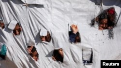Children look through holes in a tent at al-Hol displacement camp in Hasaka governorate, Syria April 2, 2019. Picture taken April 2, 2019. REUTERS/Ali Hashisho