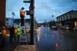 Jason Desjardin, of the Farmington Preservation & Improvement Organization, turns the Christmas lights back on in Farmington, N.H., March 19, 2020.