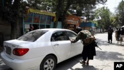 Taliban fighters search a vehicle at a checkpoint on the road in the Wazir Akbar Khan neighborhood in the city of Kabul, Afghanistan, Aug. 22, 2021. 
