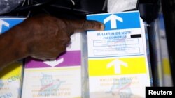 An agent of Congo's National Independent Electoral Commission points at ballots before voting starts at a poling station in Kinshasa, Democratic Republic of Congo, Dec. 30, 2018.
