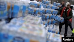 FILE - Volunteers distribute bottled water to residents in Flint, Michigan, March 5, 2016. 