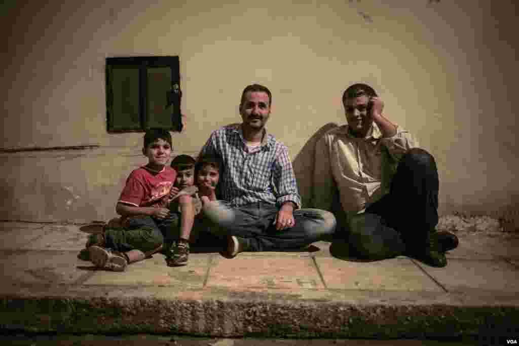 A family waits outside the hotel hoping to be allowed entry. However, City Plaza's popularity means it is now full. (J. Owens/VOA)