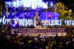 FILE - Women hold a giant banner reading 'Abolition of prostitution' during a demonstration to mark the International Day for the Elimination of Violence against Women in Madrid on Nov. 25, 2019.