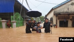 មន្ត្រីប៉ូលិសកំពុងជួយសង្គ្រោះប្រជាពលរដ្ឋពីតំបន់ទឹកលិចដោយសារភ្លៀងធ្លាក់ខ្លាំងដែលបង្កជាទឹកជំនន់ នៅខេត្តព្រះសីហនុ។ (រូបដកស្រង់ពីបណ្តាញសង្គមហ្វេសប៊ុក)