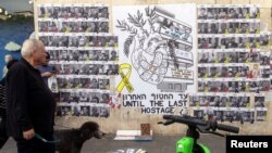 Banorë të Tel Avivit kalojnë pranë një vizatimi që bën thirrje për lirimin e të gjitha pengjeve të rrëmbyera nga Hamasi, që po mbahen në Gazë, më 17 shkurt, 2025/Reuters 