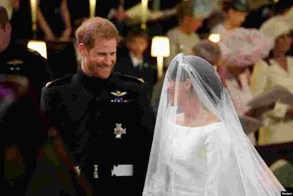 Prince Harry looks at his bride, Meghan Markle, as she arrives accompanied by the Prince of Wales in St George's Chapel at Windsor Castle for their wedding in Windsor, Britain, May 19, 2018.