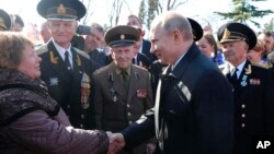 Russian President Vladimir Putin, right, meets with local residents and veterans at the historical memorial the Malakhov Kurgan (Malakoff redoubt) in Sevastopol, Crimea, Monday, March 18, 2019. (Mikhail Klimentyev, Sputnik, Kremlin Pool Photo via AP)