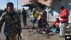 Les policiers pakistanais et des secouristes sur ​​le site de l'attentat-suicide à Quetta , au Pakistan , mercredi 13 janvier 2016 .